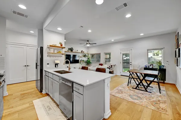 a large kitchen with kitchen island a sink a stove a dining table and chairs