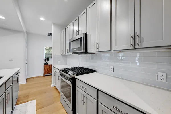 a kitchen with stainless steel appliances granite countertop a sink stove and cabinets