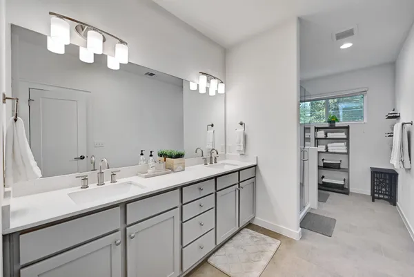 a spacious bathroom with a double vanity sink and a mirror