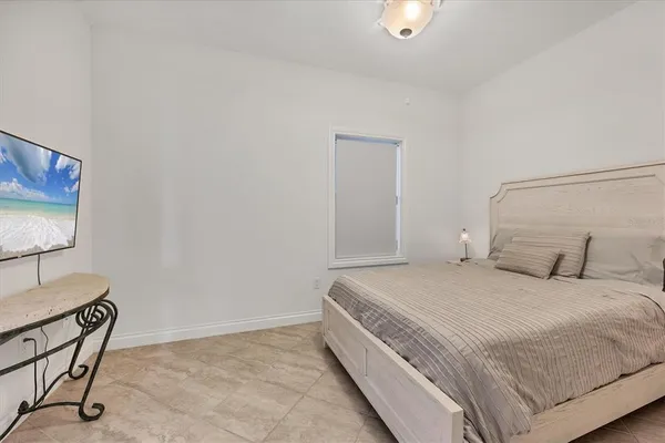 a bedroom with a bed and a lamp on dresser