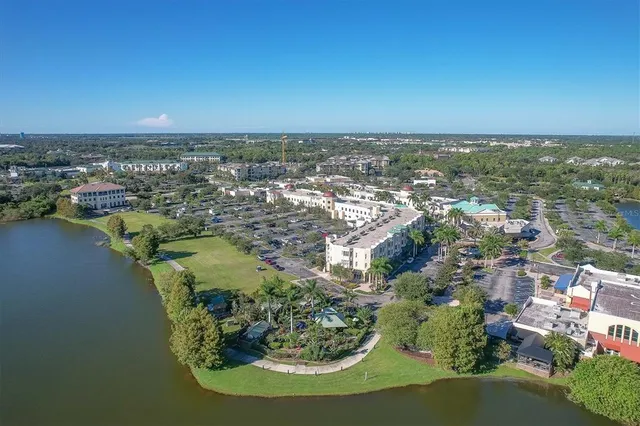 an aerial view of residential houses with outdoor space and lake view