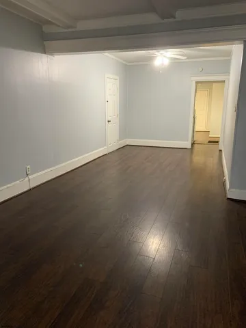 en empty room with wooden floor and windows
