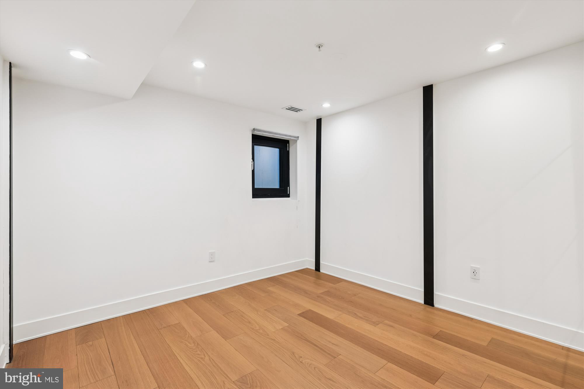 746 Morton Street Northwest, Unit 1 Washington, DC 20010 - Photo 21 of 35 an empty room with wooden floor and windows