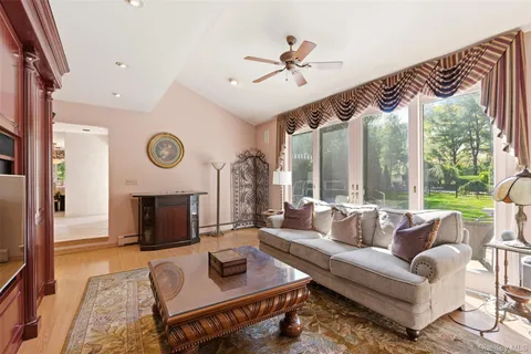 a living room with furniture a fireplace and a large window