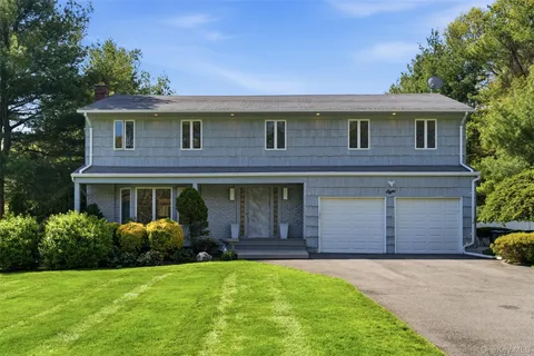 a front view of a house with a garden and garage