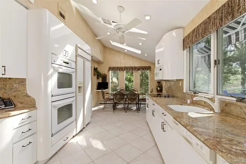a large white kitchen with a large window