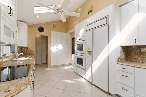 a kitchen with stainless steel appliances kitchen island granite countertop a refrigerator and a stove