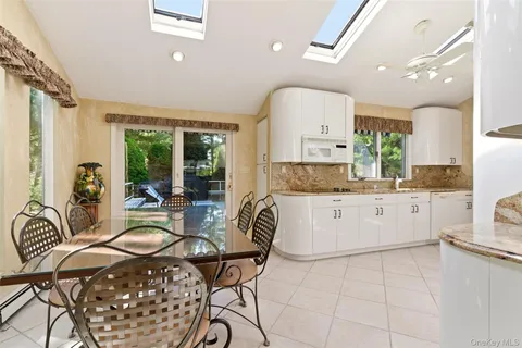 a kitchen with a dining table chairs and white cabinets