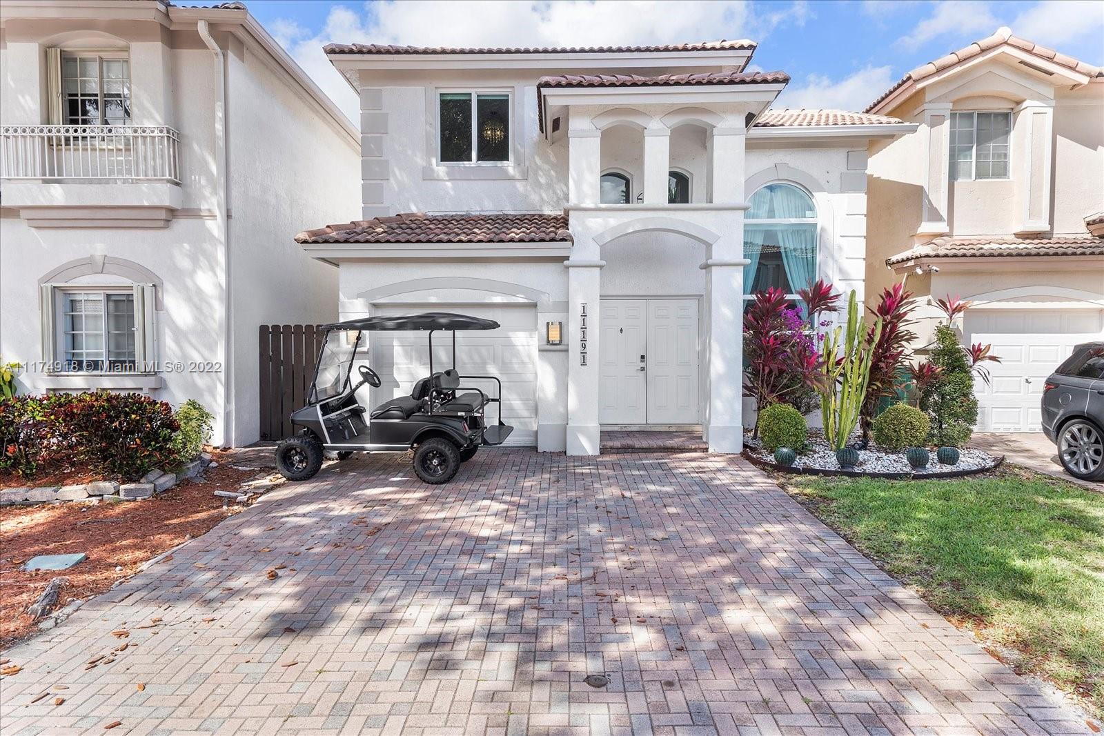 a view of a white house with many windows and a table and chairs in patio