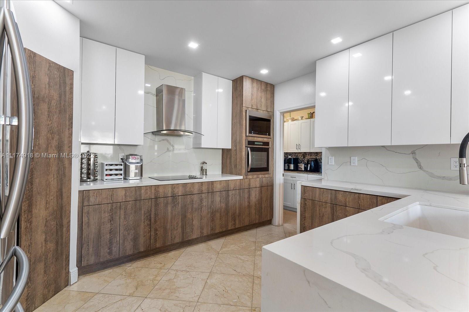 Doral Isles Doral, FL 33178 - Photo 16 of 38 a kitchen with kitchen island granite countertop a stove sink and refrigerator