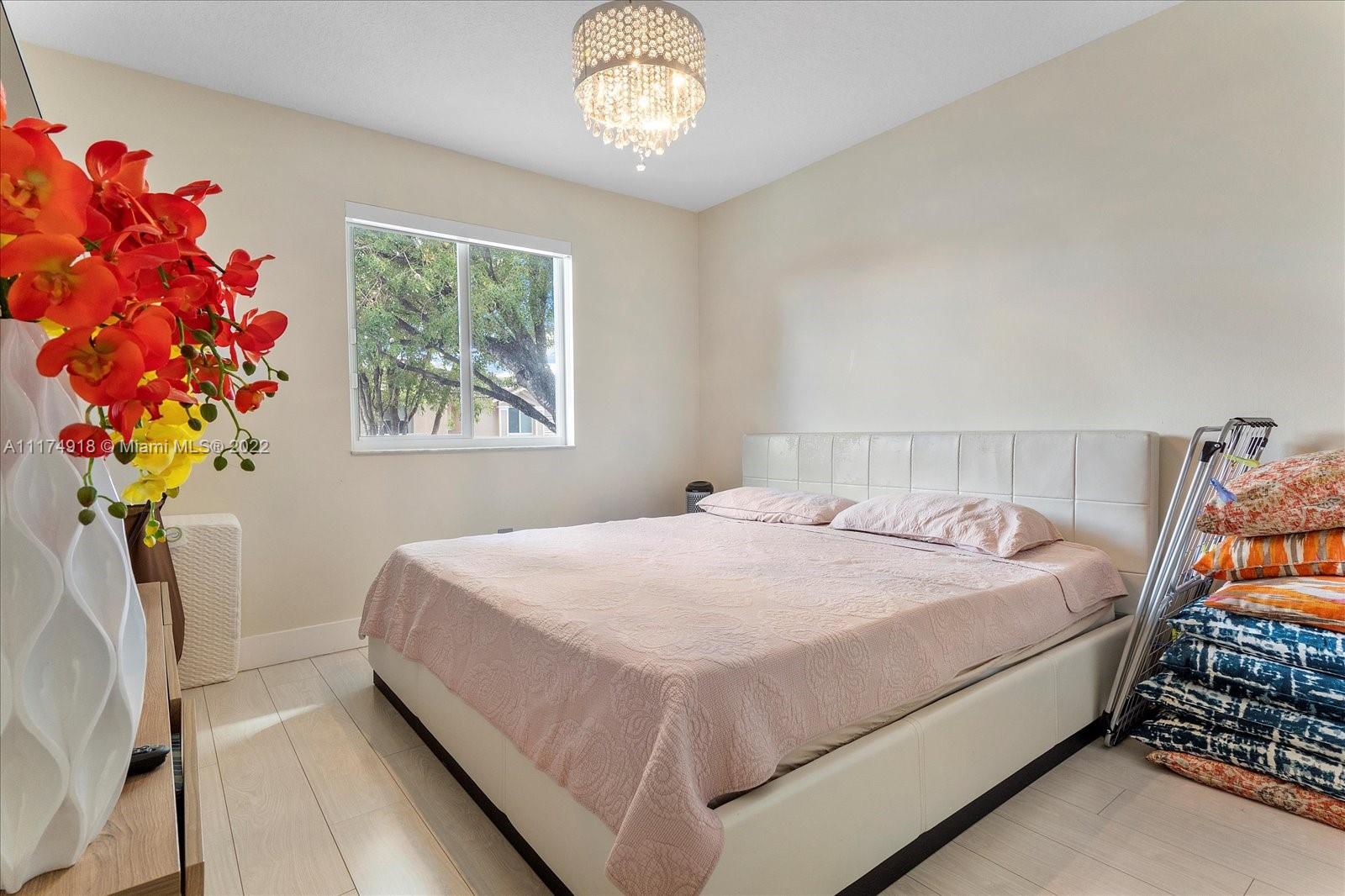 Doral Isles Doral, FL 33178 - Photo 23 of 38 a bed sitting in a bedroom next to a window