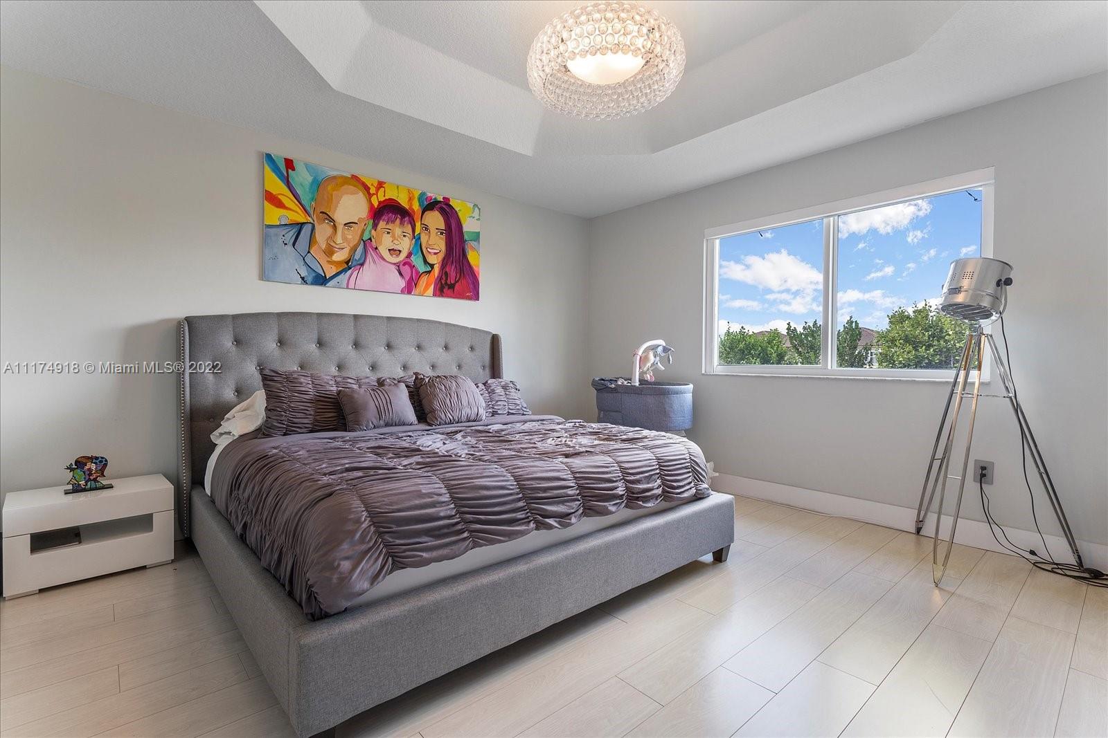 Doral Isles Doral, FL 33178 - Photo 27 of 38 a bedroom with a bed and a painting on the wall