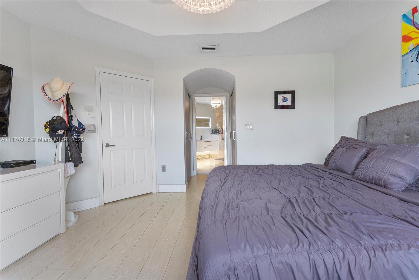 Doral Isles Doral, FL 33178 - Photo 28 of 38 a bedroom with a bed and a chandelier