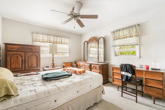 a bedroom with a bed dresser and a window