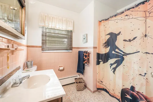 a bathroom with a sink and mirror with bathtub