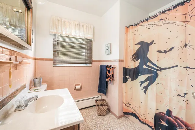 a bathroom with a sink and mirror with bathtub