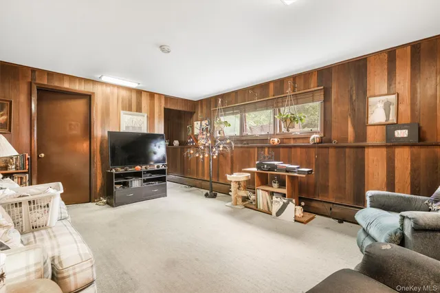 a living room with furniture a flat screen tv and a large window