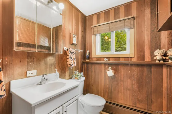 a bathroom with a sink a toilet and a mirror