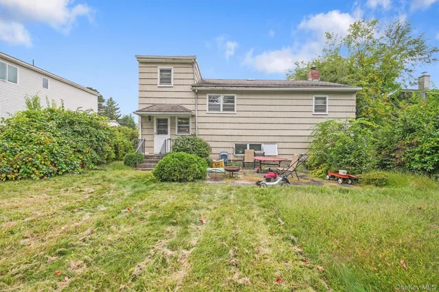 a view of a house with backyard and sitting area