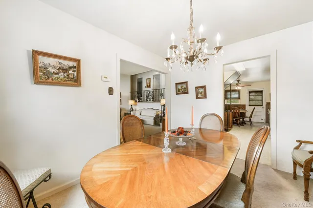 a view of a dining room with furniture a chandelier and wooden floor