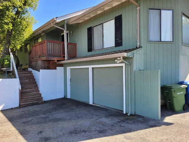 a view of a house with a door and wooden bench