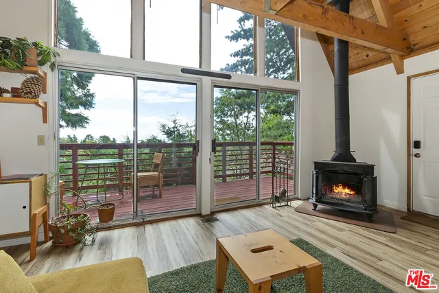 a living room with furniture large window and a fireplace