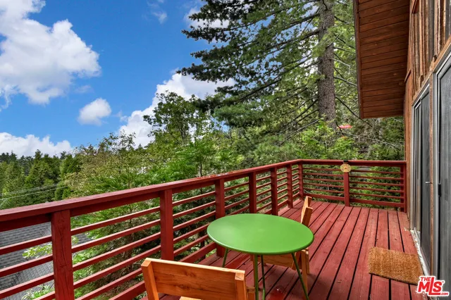 a balcony with wooden floor and outdoor seating