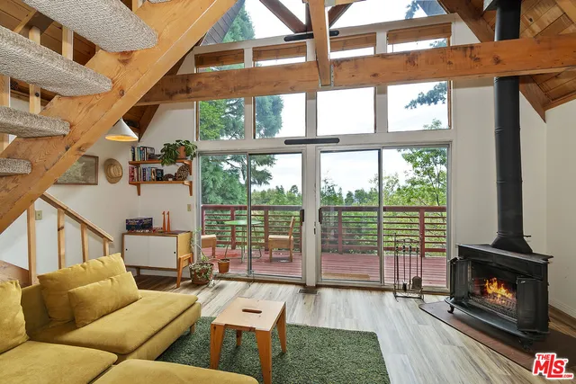 a living room with furniture large window and wooden floor