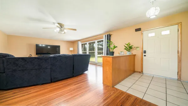 a living room with furniture a flat screen tv and a large window