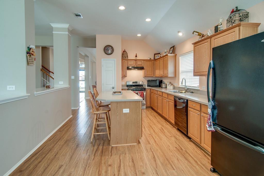 13049 Fencerow Road Fort Worth, TX 76244 - Photo 13 of 32 a large kitchen with stainless steel appliances a lot of counter space and a wooden floors
