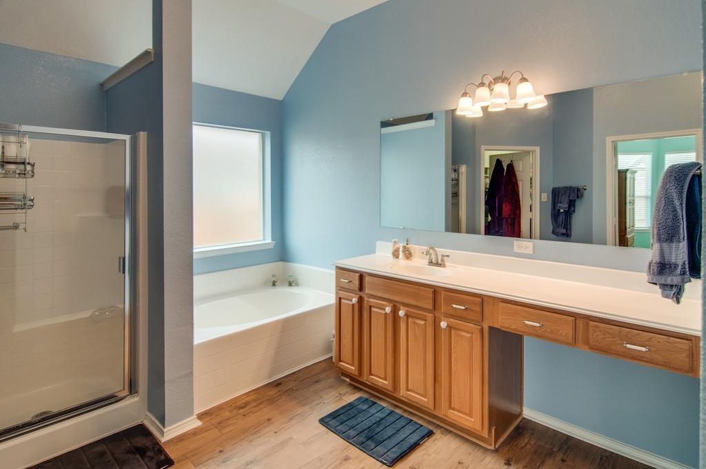 13049 Fencerow Road Fort Worth, TX 76244 - Photo 17 of 32 a spacious bathroom with a bathtub a sink and a large mirror