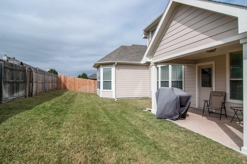 13049 Fencerow Road Fort Worth, TX 76244 - Photo 23 of 32 a view of backyard with seating space and wooden fence
