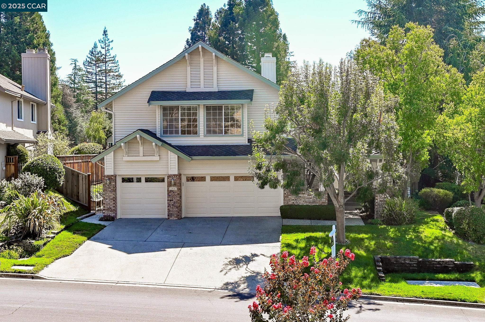 a front view of a house with a yard and potted plants