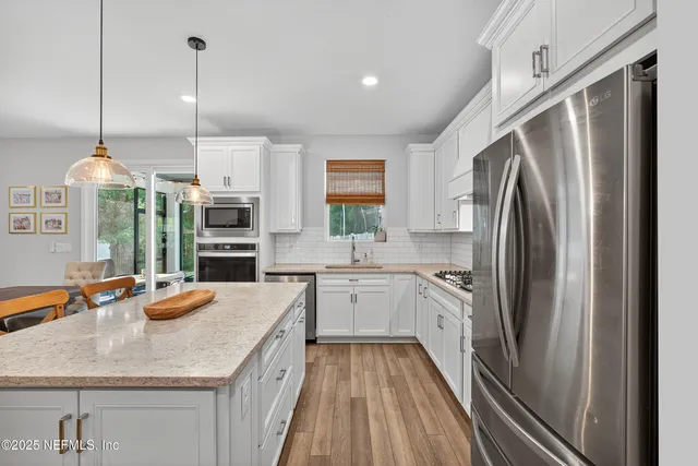 a kitchen with a table chairs refrigerator and microwave