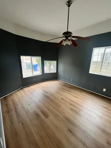 a view of empty room with window and ceiling fan