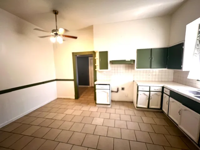 a view of a kitchen with a sink and a refrigerator