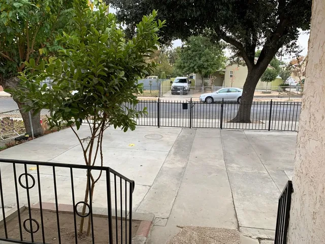 a view of a patio with table and chairs and a large tree