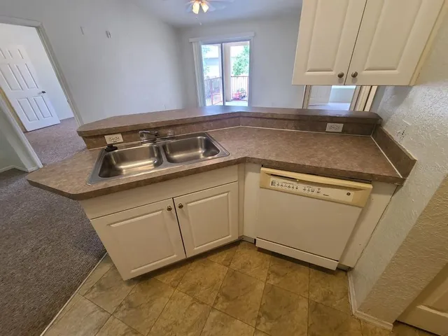 a kitchen with white cabinets and white appliances