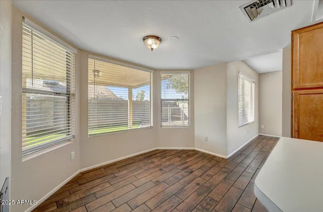 a view of a livingroom with wooden floor and windows