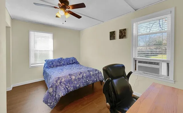 a bedroom with a bed and wooden floor