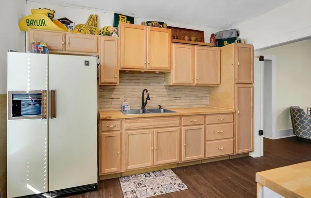 a kitchen with stainless steel appliances a refrigerator sink and cabinets