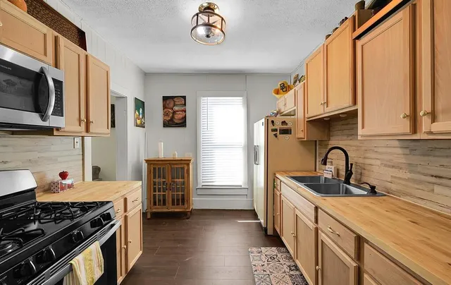 a kitchen with stainless steel appliances a stove a sink and a microwave