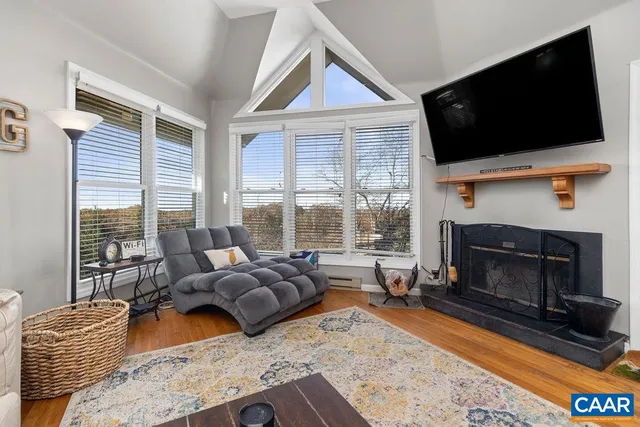 a living room with furniture a flat screen tv and a fireplace