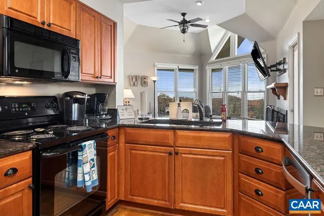 a kitchen with stainless steel appliances granite countertop a refrigerator a stove and a sink