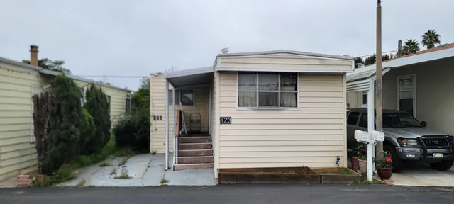 a view of a house with a yard and potted plants