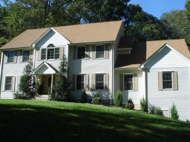 a front view of a house with a yard and green space