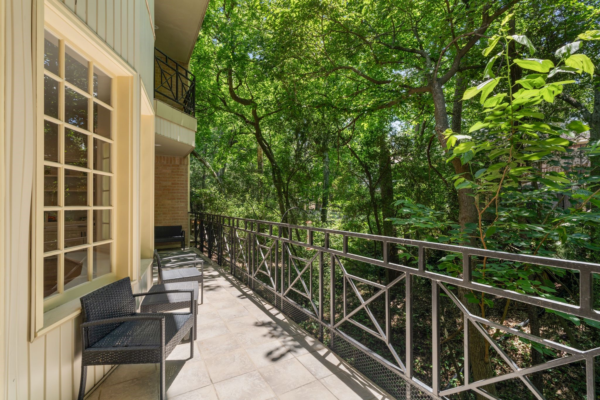 201 Vanderpool Lane, Unit 137 Houston, TX 77024 - Photo 3 of 42 The full width balcony extends the living space outdoors, offering a quiet place to enjoy morning coffee, fresh air, and views surrounded by mature trees, adding to the home's quiet, tucked away feel.