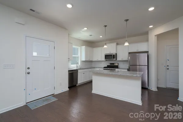 a kitchen with stainless steel appliances kitchen island sink refrigerator and microwave