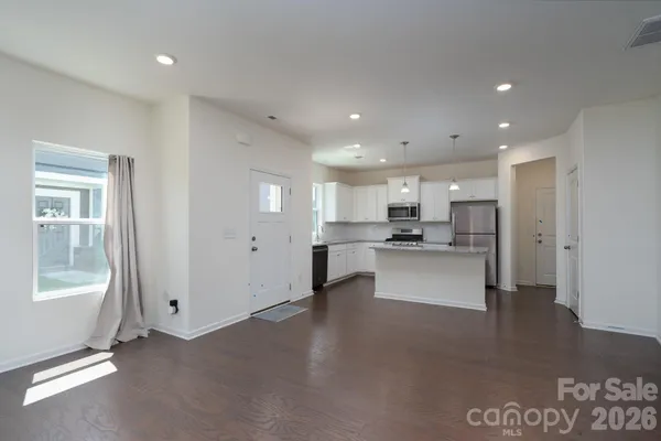 a view of kitchen with kitchen island stainless steel appliances refrigerator stove microwave and cabinets