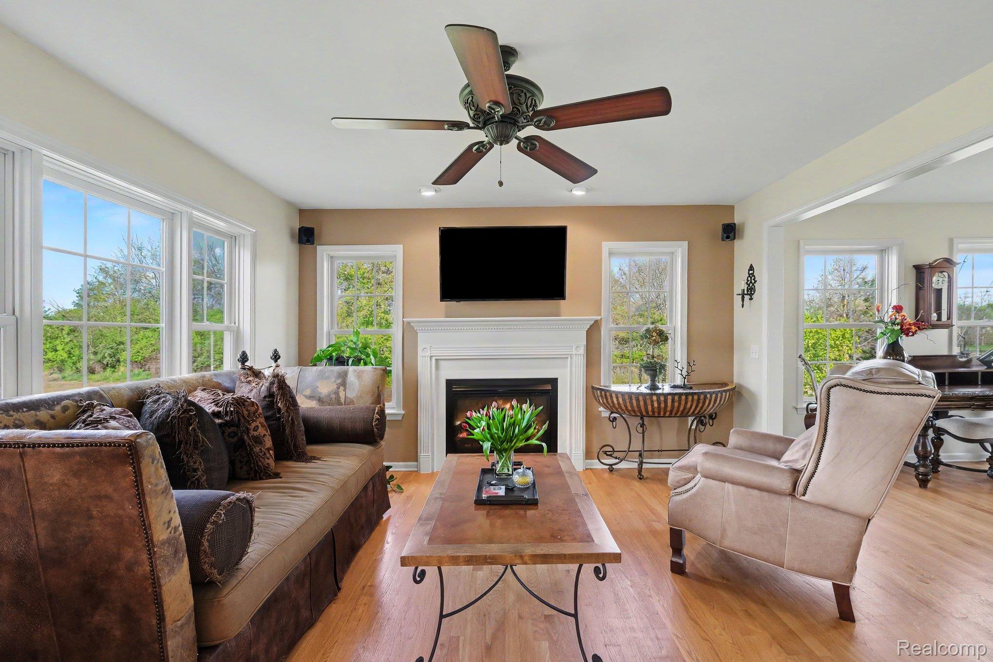 6520 Cook Road Swartz Creek, MI 48473 - Photo 11 of 43 Living room featuring a ceiling fan, light wood-style floors, and a fireplace